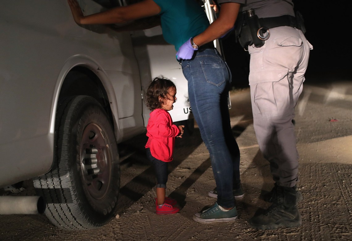 A Honduran asylum seeker being searched by a Border Patrol agent while her two-year-old cries, McAllen, Texas